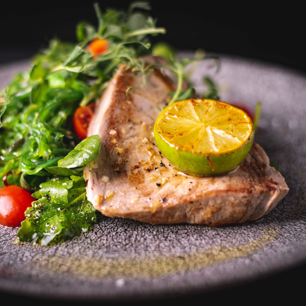 Thunfischsteak Sous Vide wird mit Limette an Salat serviert.