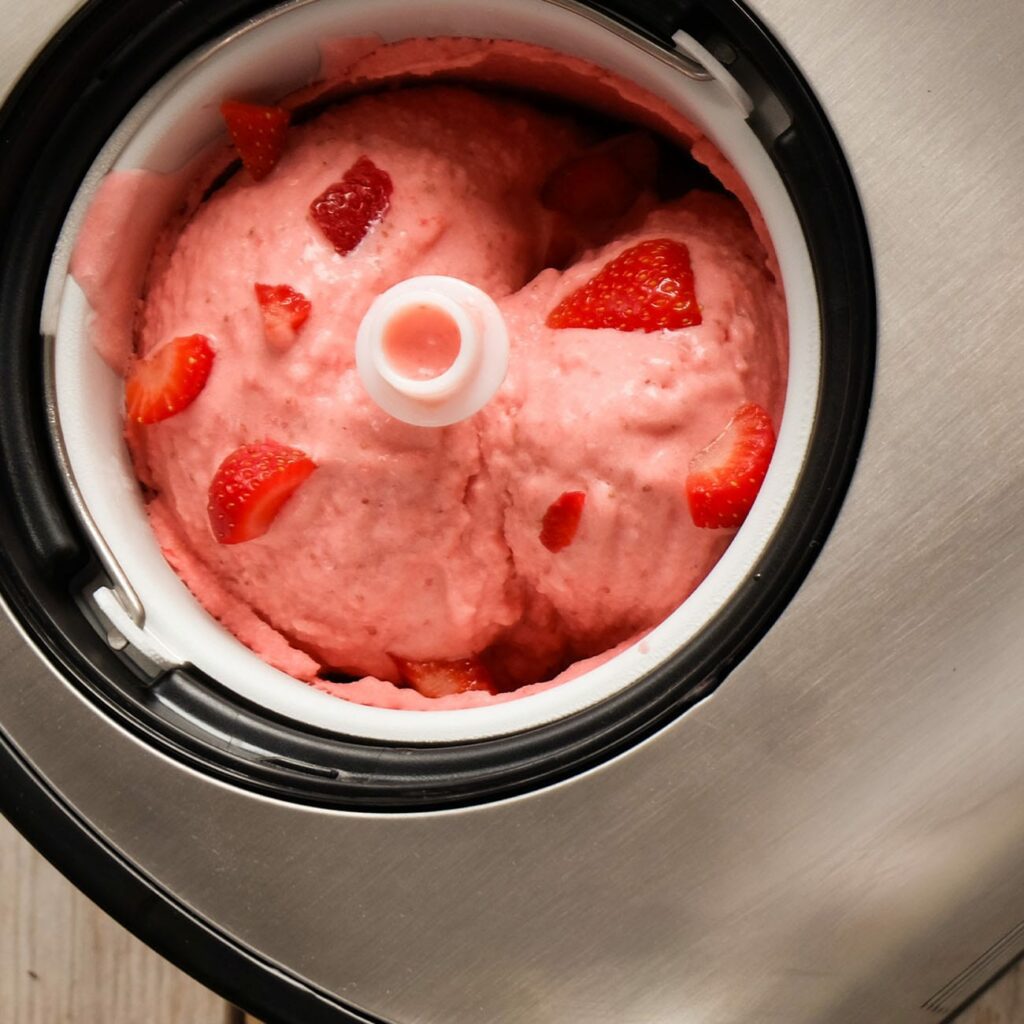 Eis selber machen: Erdbeereis wird in der Eismaschine gezeigt.