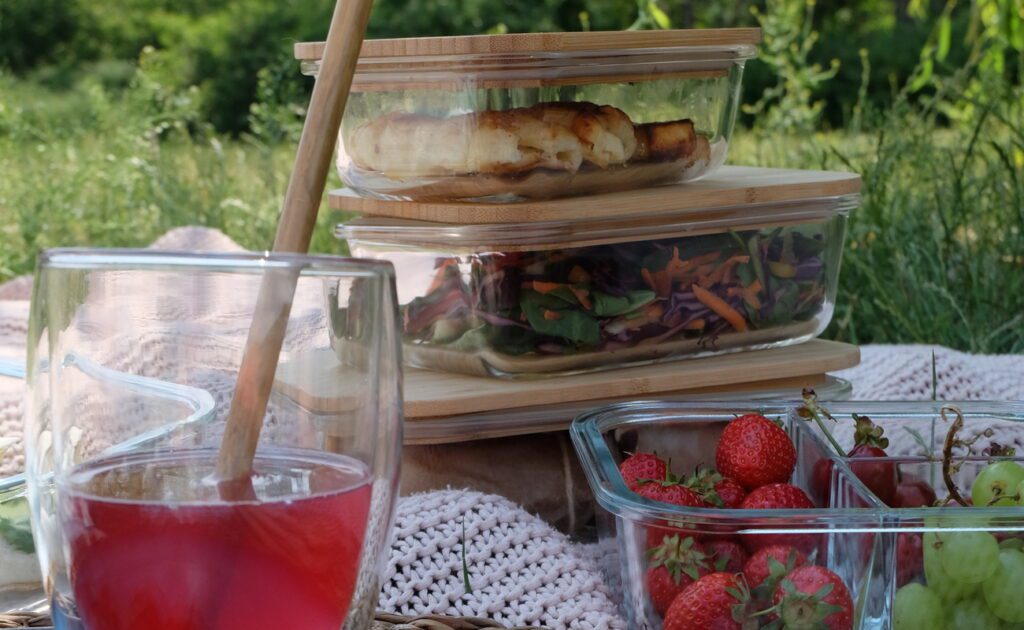 Gesunde Snacks: Praktische Lunchboxen von Klarstein werden auf einer Picknick Decke gezeigt.