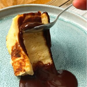 Burnt Basque Cheesecake wird mit Schoko-Sauce serviert.