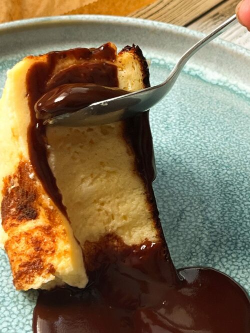 Burnt Basque Cheesecake wird mit Schoko-Sauce serviert.